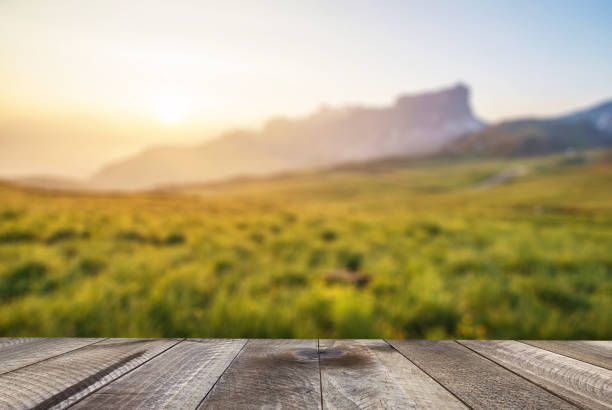 mesa de madera vacía con el paisaje montañoso al atardecer. - on top of grass scenics field fotografías e imágenes de stock