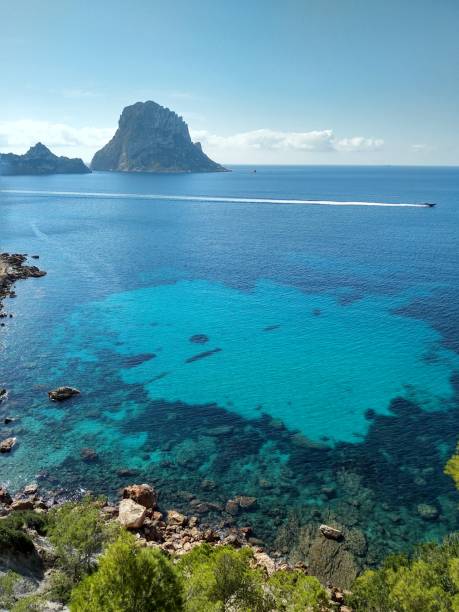 beautiful panorama of the islet of Es Vedra on the cliff of Cala D'Hort in Ibiza, Pitiusa Island of the Balearics beautiful panorama of the islet of Es Vedra on the cliff of Cala D'Hort in Ibiza, Pitiusa Island of the Balearics balearics stock pictures, royalty-free photos & images