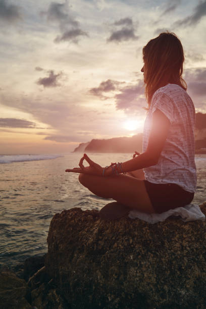 istock Young woman practicing yoga - meditation on the beach. 1138676852