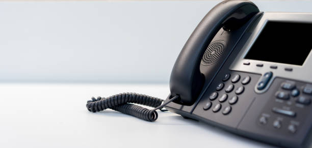 close up telephone VOIP technology standing on office desk in office room for network operation center job concept close up telephone VOIP technology standing on office desk in monitoring room for network operation center job concept telephone receiver stock pictures, royalty-free photos & images