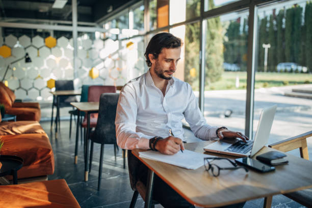 istock Businessman working on laptop in cafe 1138678645