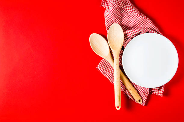 istock Kitchen textiles and wooden spoons on bright red background 1138679239