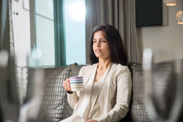 istock mature woman sitting on couch at home 1138680247