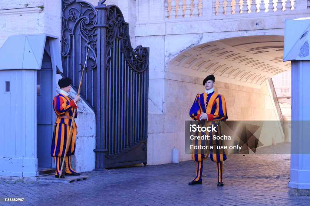 Swiss Guards standing by a gate The Swiss Guards are guarding Gate of St. Peter's Basilica Armed Forces Stock Photo