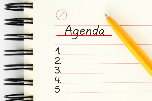 Blank Agenda List handwritten on notebook page next to yellow pen with copy space. Business or personal planner, schedule or organizer concept.