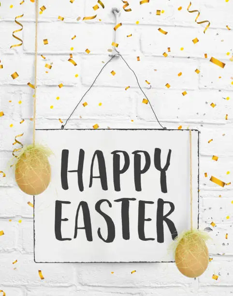 Spring quotes handwritten text on sign board with happy easter brown yellow egg
