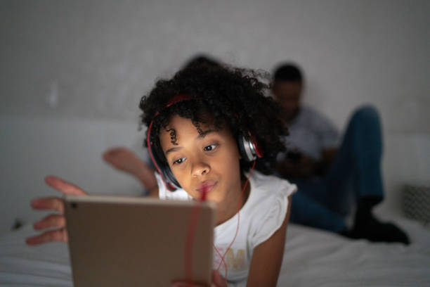 latynoska dziewczyna za pomocą cyfrowego tabletu w sypialni - wireless technology serious education enjoyment zdjęcia i obrazy z banku zdjęć