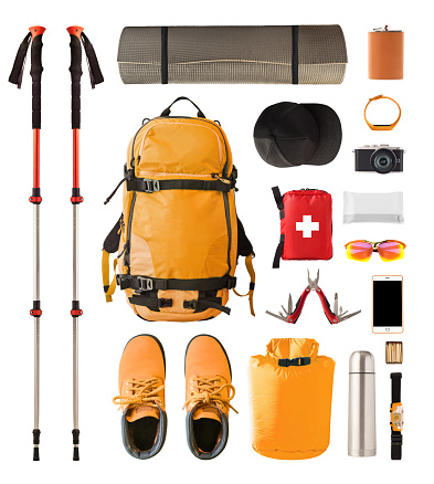 Set of sport equipment and gear for hiking and trekking. Top view of walking sticks, backpack, clothes etc. isolated on white background