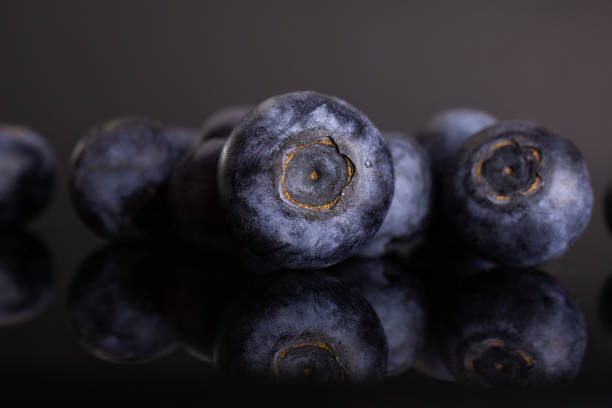 Fresh sweet blueberry isolated on black glass