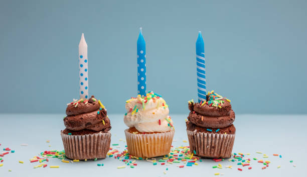 istock Birthday cupcakes with candles on blue pastel background, copy space. 1138692754