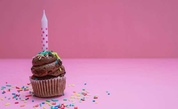 istock Birthday cupcake with candle on pink pastel background, copy space. 1138692755