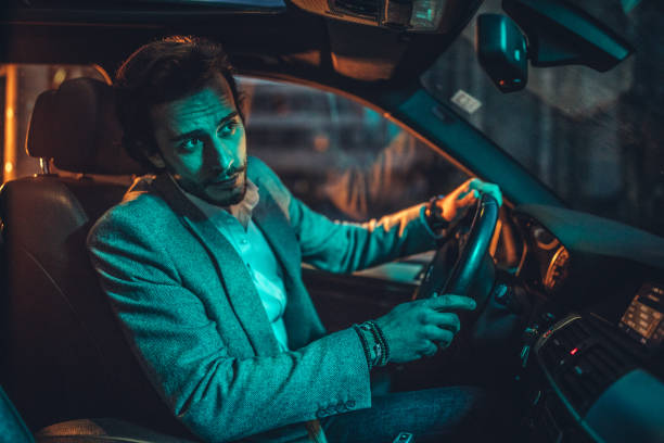 istock Businessman Driving A Car In Night 1138694150