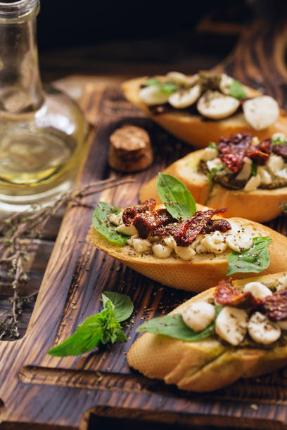 istock sandwich with mozzarella cheese, pesto, sun-dried tomatoes and basil and thyme, served on the wooden board 1138697901