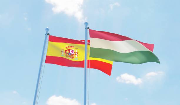 istock Hungary and Spain, two flags waving against blue sky 1138697975