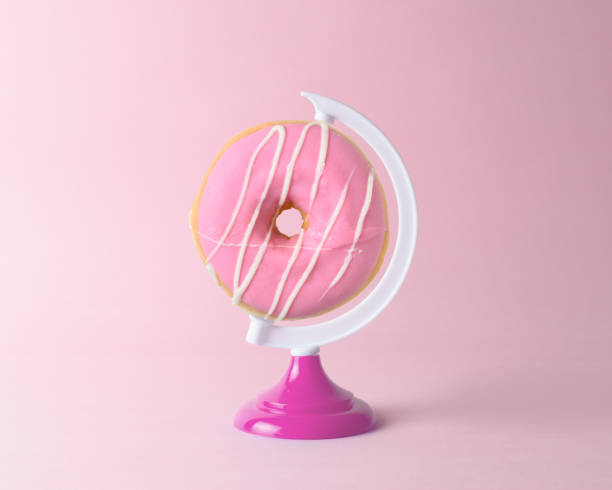 istock Donut on a globe stand on pastel pink background. Minimal concept. 1138701779