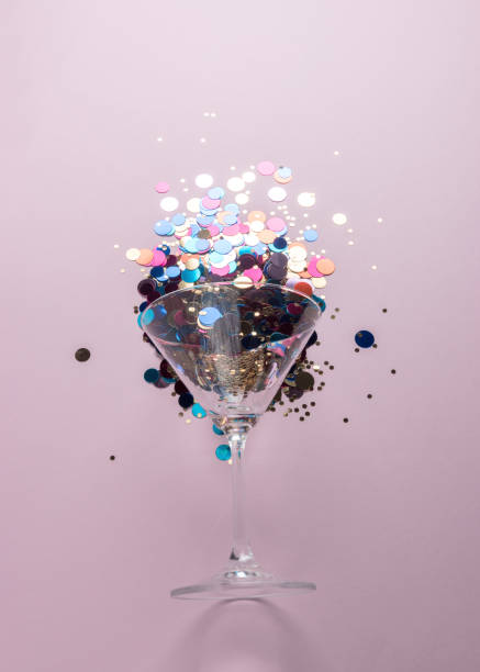 istock Martini glass with colorful glitters on pink background. Creative minimal party concept. 1138701802