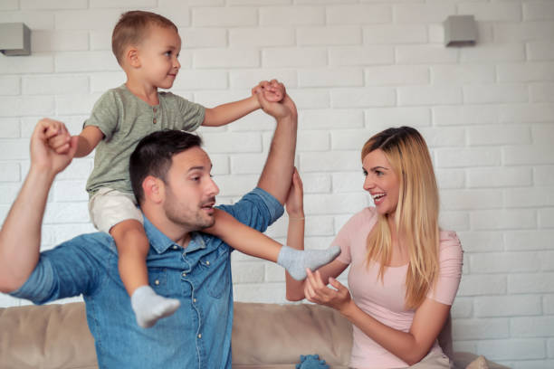 istock Cheerful parents playing with their little son at home 1138705387