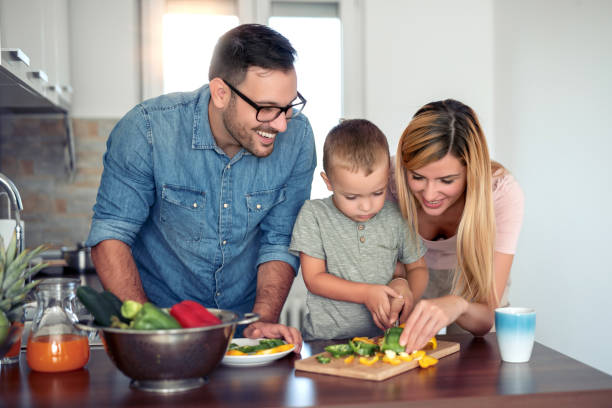 istock Happy young family preparing lunch in the kitchen 1138705393