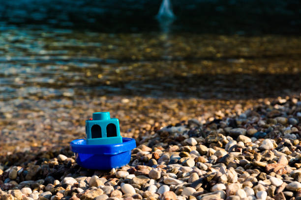 Toy boat on the beach on a sunny day stock photo
