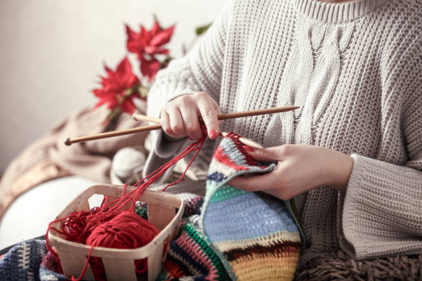 istock woman knits knitting needles on the couch 1138709928