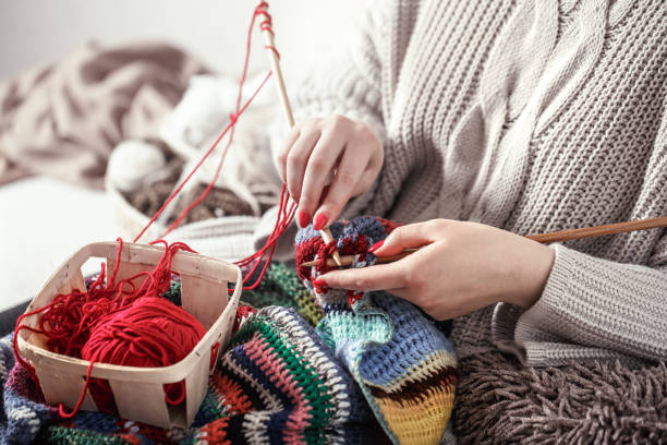 istock woman knits knitting needles on the couch 1138709934