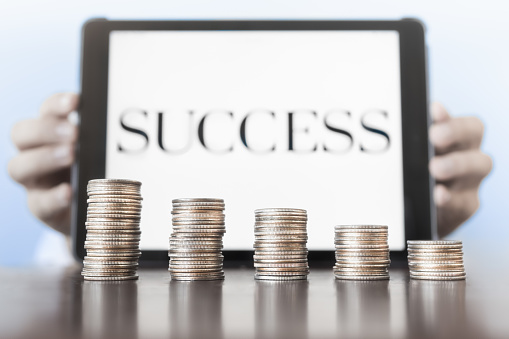 Businessman holding tablet with success word on it.