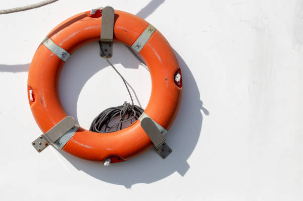 Red emergency lifebuoy hanging on the side of a fishing boat. stock photo