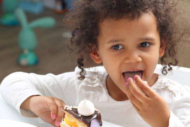 istock little black girl eating a cake 1138714642