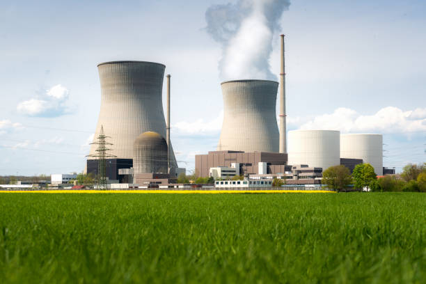istock Nuclear power plant with yellow field and big blue clouds. 1138716034
