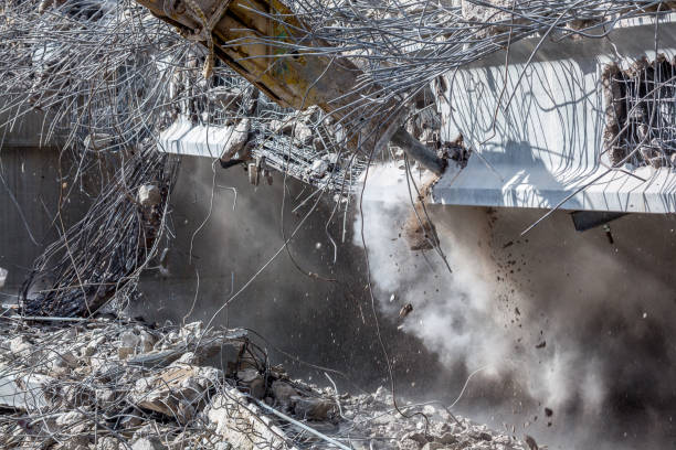 istock Professional demolition of reinforced concrete structures using industrial hydraulic hammer. Rods of metal fittings. Wreckage and crumbles of concrete. 1138716059