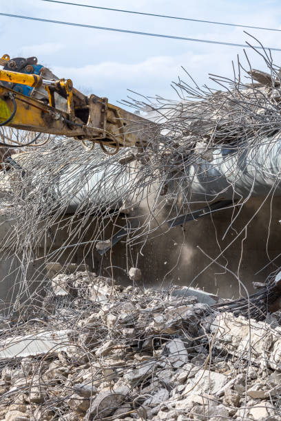 istock Professional demolition of reinforced concrete structures using industrial hydraulic hammer. Rods of metal fittings. Wreckage and crumbles of concrete. 1138716069
