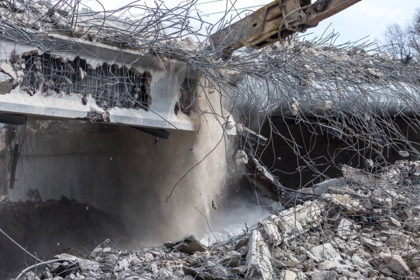 istock Professional demolition of reinforced concrete structures using industrial hydraulic hammer. Rods of metal fittings. Wreckage and crumbles of concrete. 1138716080