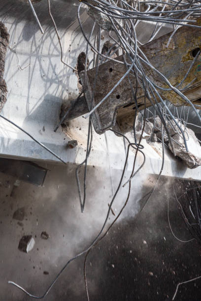 istock Professional demolition of reinforced concrete structures using industrial hydraulic hammer. Rods of metal fittings. Wreckage and crumbles of concrete. 1138716081