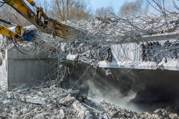 istock Professional demolition of reinforced concrete structures using industrial hydraulic hammer. Rods of metal fittings. Wreckage and crumbles of concrete. 1138716083