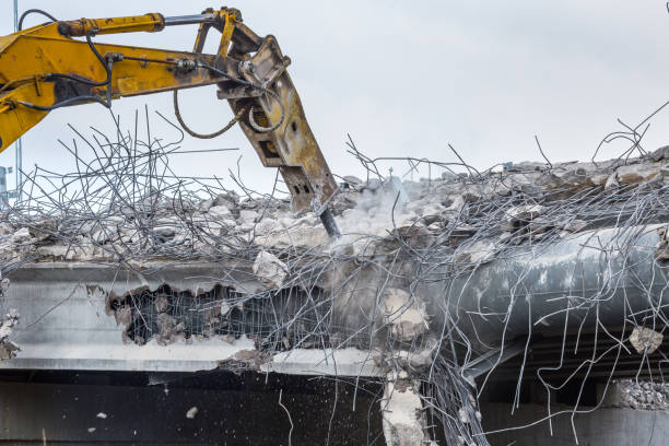istock Professional demolition of reinforced concrete structures using industrial hydraulic hammer. Rods of metal fittings. Wreckage and crumbles of concrete. 1138716110