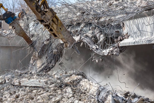 istock Professional demolition of reinforced concrete structures using industrial hydraulic hammer. Rods of metal fittings. Wreckage and crumbles of concrete. 1138716121
