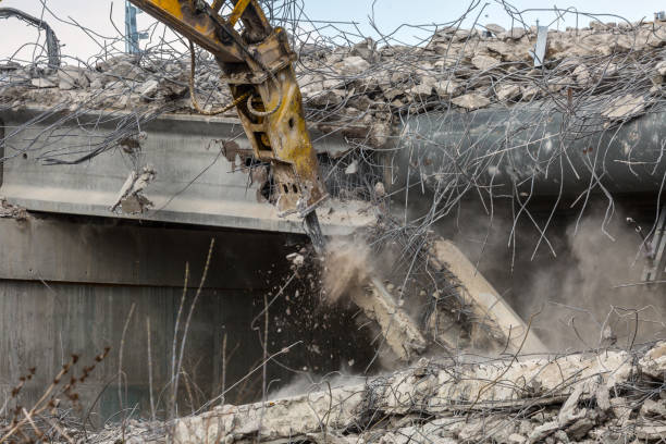 istock Professional demolition of reinforced concrete structures using industrial hydraulic hammer. Rods of metal fittings. Wreckage and crumbles of concrete. 1138716149