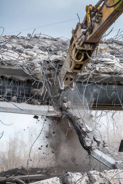 istock Professional demolition of reinforced concrete structures using industrial hydraulic hammer. Rods of metal fittings. Wreckage and crumbles of concrete. 1138716154