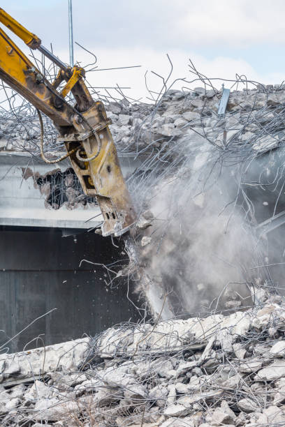 istock Professional demolition of reinforced concrete structures using industrial hydraulic hammer. Rods of metal fittings. Wreckage and crumbles of concrete. 1138716162