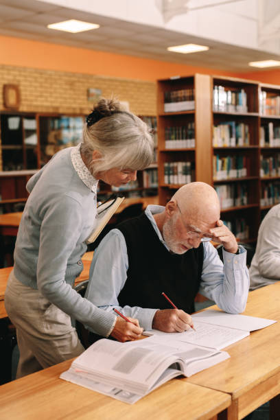 istock Senior lecturer helping an elderly man in university class 1138716168