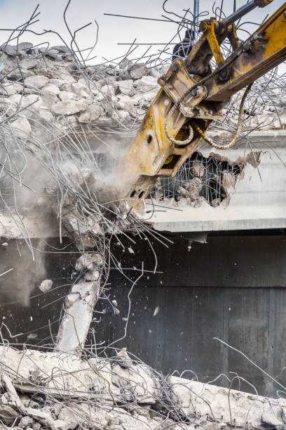 istock Professional demolition of reinforced concrete structures using industrial hydraulic hammer. Rods of metal fittings. Wreckage and crumbles of concrete. 1138716191