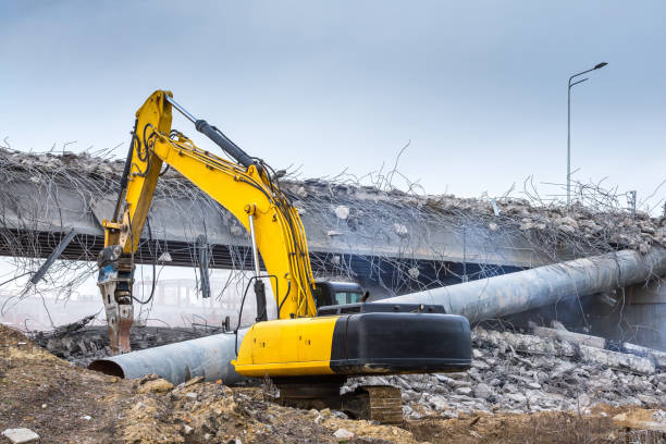 Professional demolition of reinforced concrete structures using industrial hydraulic hammer. Rods of metal fittings. Wreckage and crumbles of concrete. Professional demolition of reinforced concrete structures using industrial hydraulic hammer. Rods of metal fittings. Wreckage and crumbles of concrete. deconstruct stock pictures, royalty-free photos & images