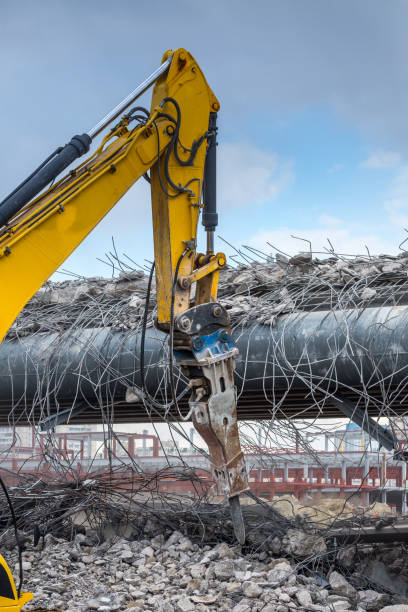 istock Professional demolition of reinforced concrete structures using industrial hydraulic hammer. Rods of metal fittings. Wreckage and crumbles of concrete. 1138716227