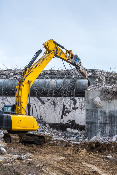 istock Professional demolition of reinforced concrete structures using industrial hydraulic hammer. Rods of metal fittings. Wreckage and crumbles of concrete. 1138716234