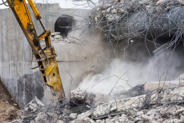 istock Professional demolition of reinforced concrete structures using industrial hydraulic hammer. Rods of metal fittings. Wreckage and crumbles of concrete. 1138716235