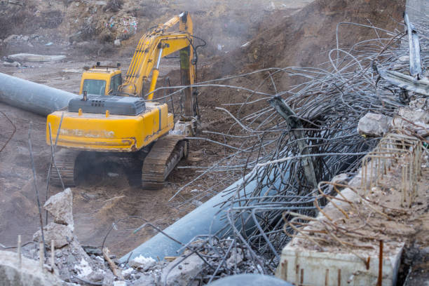 Professional demolition of reinforced concrete structures using industrial hydraulic hammer. Rods of metal fittings. Wreckage and crumbles of concrete.