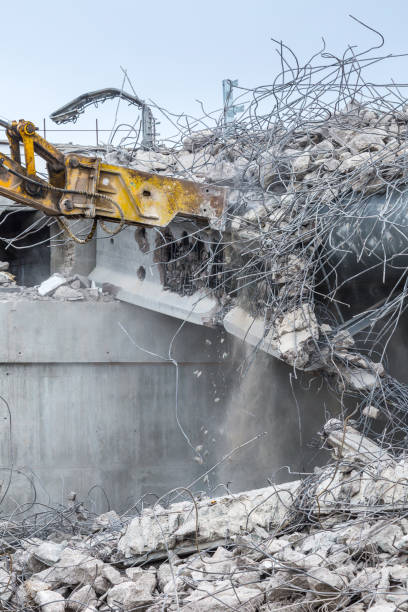 istock Professional demolition of reinforced concrete structures using industrial hydraulic hammer. Rods of metal fittings. Wreckage and crumbles of concrete. 1138716254