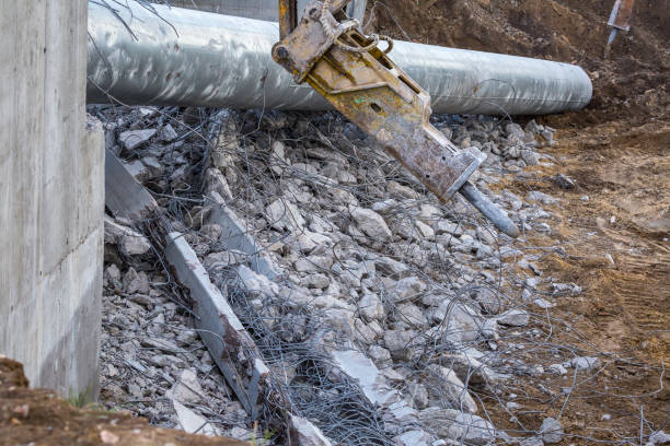 istock Professional demolition of reinforced concrete structures using industrial hydraulic hammer. Rods of metal fittings. Wreckage and crumbles of concrete. 1138716560