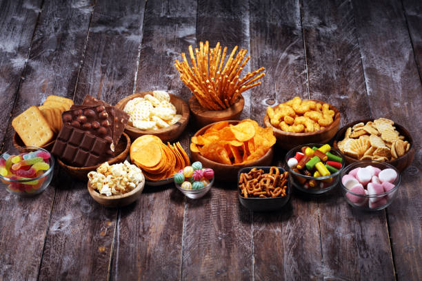 istock Salty snacks. Pretzels, chips, crackers in wooden bowls on table 1138716953
