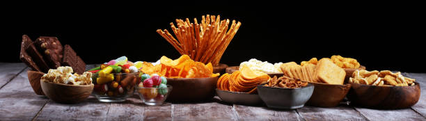istock Salty snacks. Pretzels, chips, crackers in wooden bowls on table 1138716988